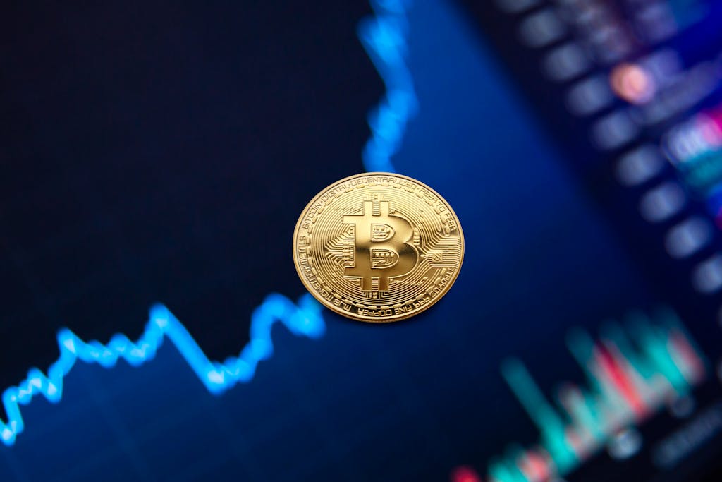 A gold Bitcoin coin against a backdrop of a digital financial chart, symbolizing cryptocurrency trading.