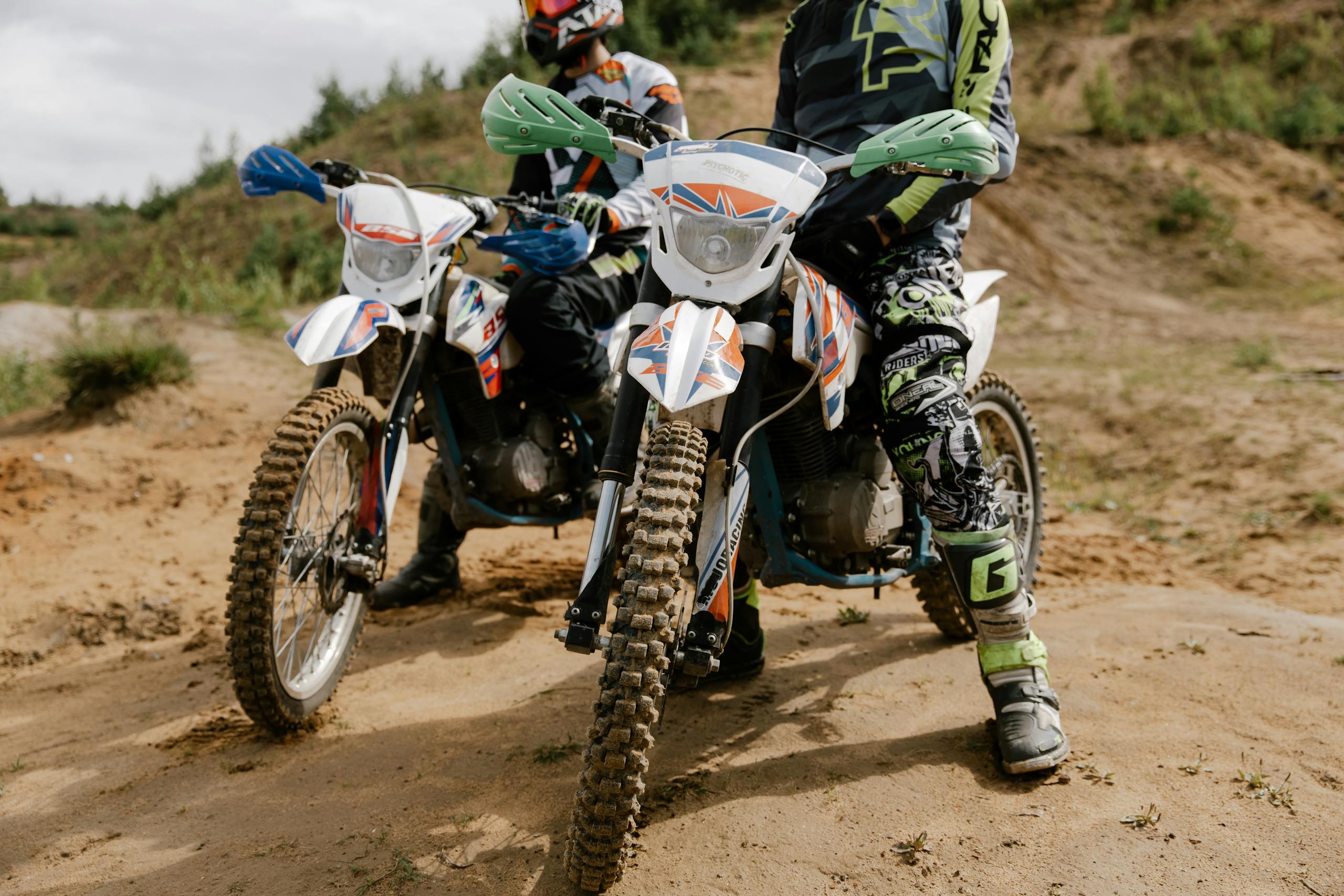 Two riders on dirt bikes ready for an off-road motocross adventure.